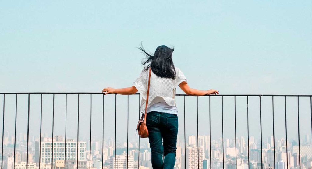 mulher observando os melhores bairros da Zona Sul de São Paulo do alto de um prédio